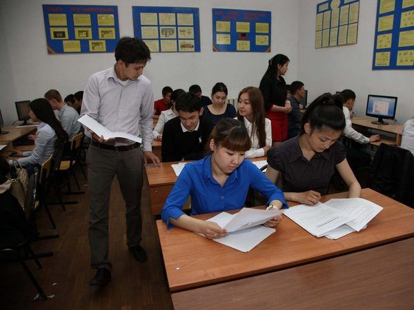 На занятии: студенты работают с документами, преподаватель рядом.