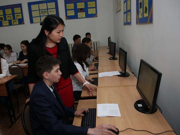 Преподаватель объясняет задание в компьютерном классе.